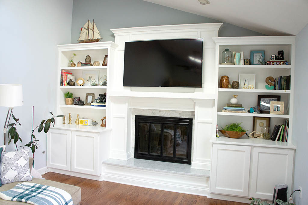 Fireplace built-ins and marble surround, TV mounted over fireplace. 