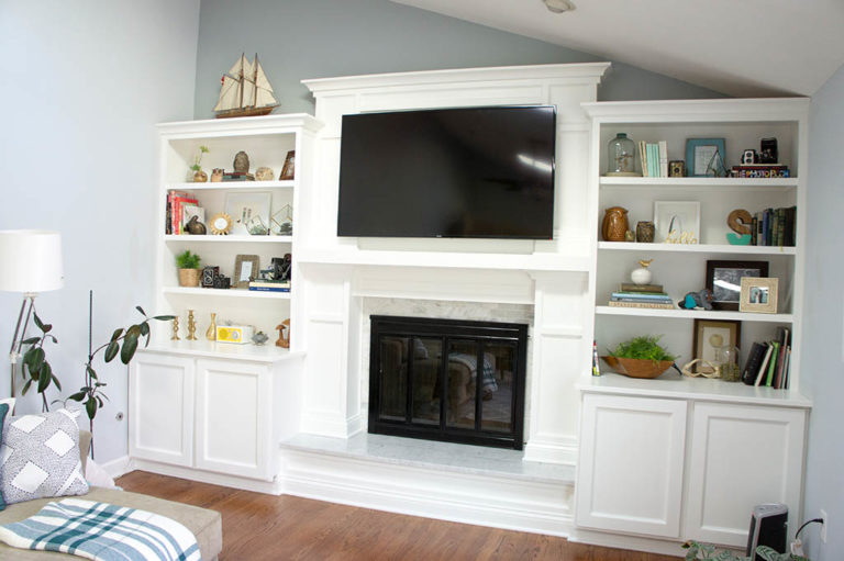 Fireplace built-ins and marble surround, TV mounted over fireplace.